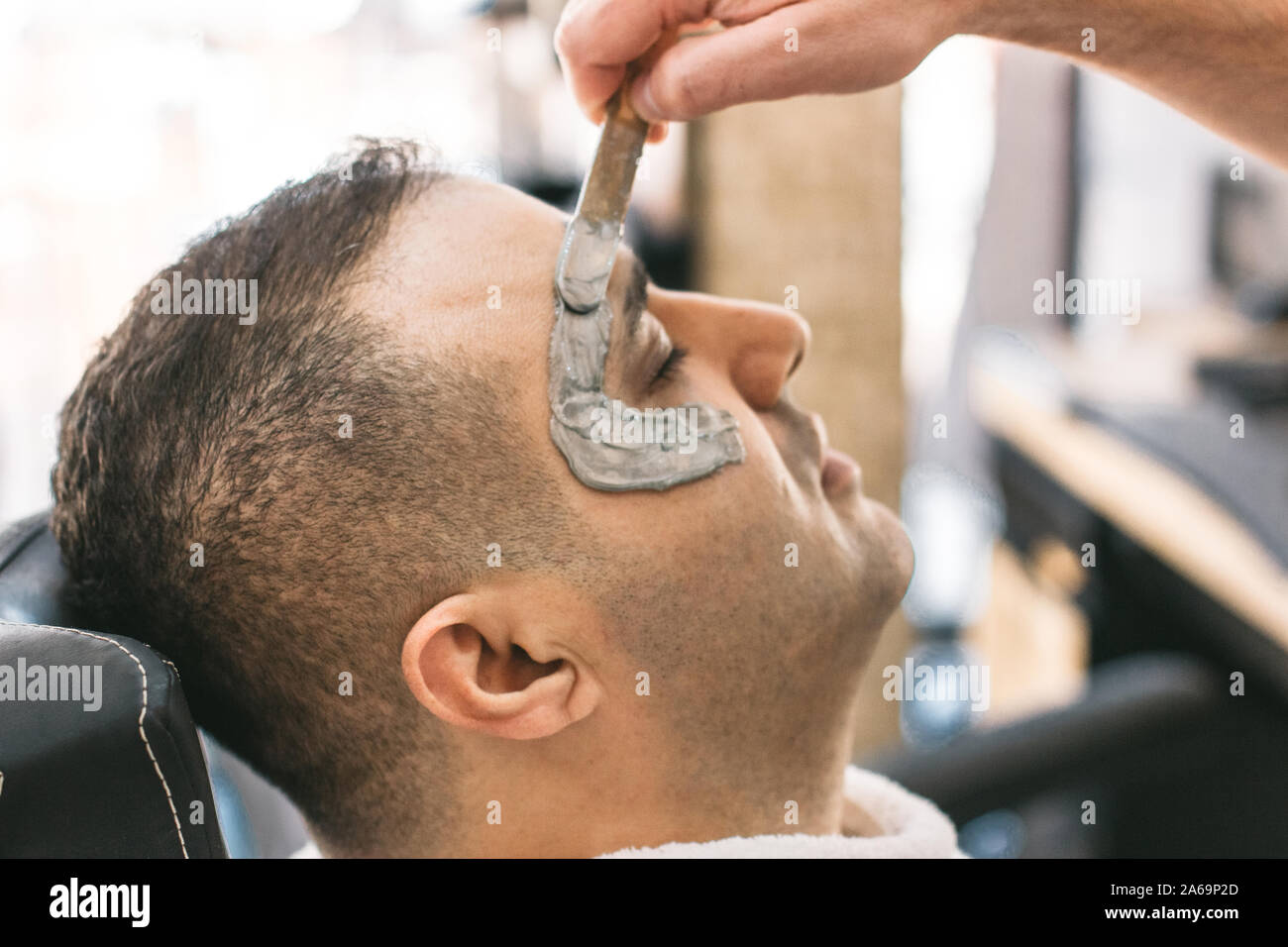 Ceretta viso maschile. il barbiere rimuove i capelli shugaring dal viso  dell'uomo turco.
