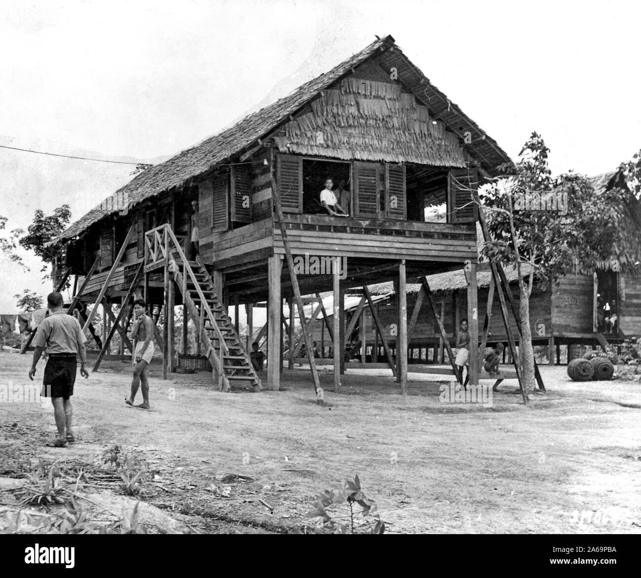 Quartieri dormitorio in un giapponese labour camp a Seletah, nella parte settentrionale di Singapore, sono in case in paglia sollevata al di sopra di terra per la protezione contro gli insetti e rettili. Circa 1700 coolies, molti da Java, furono portati qui, assegnato al lavoro forzato e costretti a vivere nella sporcizia e squallore finché un navale britannica accidentalmente partito li ha trovati. Foto Stock