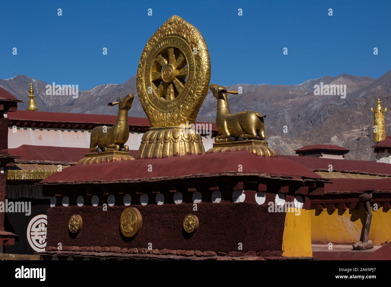 La ruota del dharma e statue di cervo sono simboli buddista sulla sommità del tempio dello Jokhang a Lhasa, in Tibet. Un sito Patrimonio Mondiale dell'UNESCO. Foto Stock