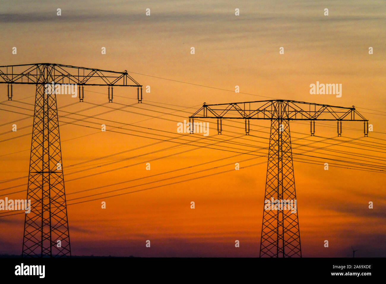 Linea di alimentazione ad alta tensione nella linea di trasmissione Sunset Pylons Germany ENERGY Foto Stock