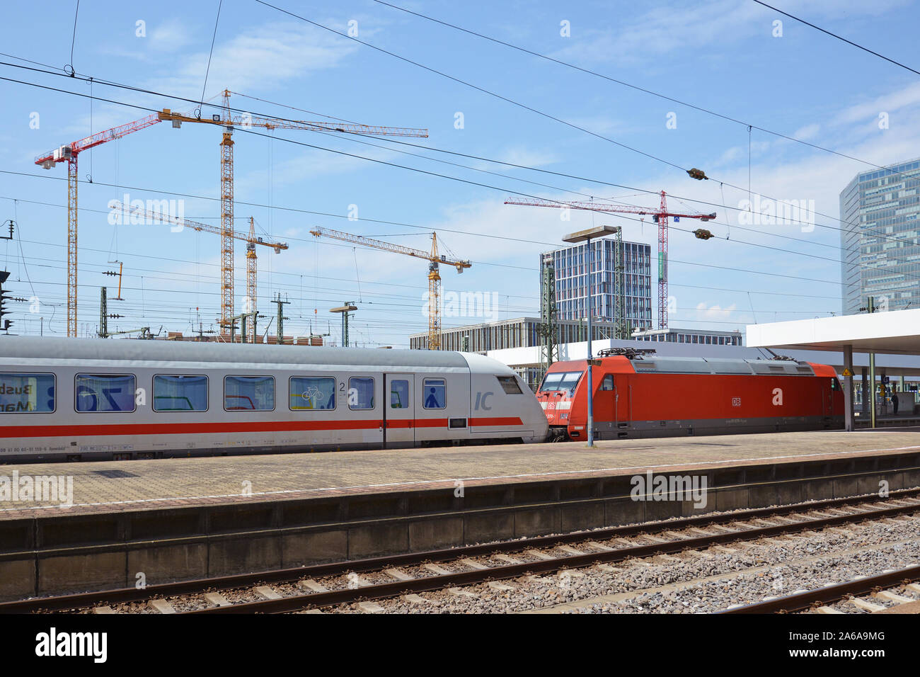 Le vie e le piattaforme di Mannheim stazione ferroviaria principale con il tedesco "IC" Intercity treno passa attraverso il giorno di estate con cielo blu Foto Stock