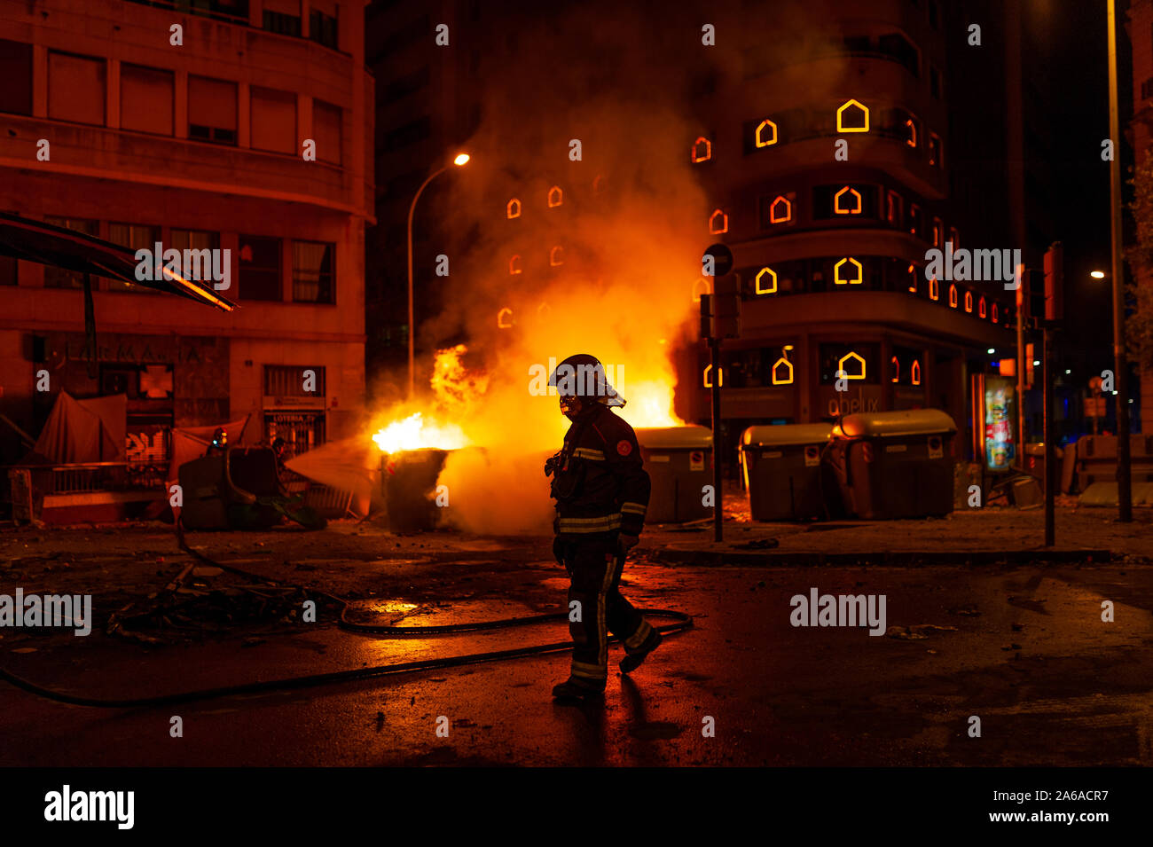 Barcellona, Spagna - 19 ottobre 2019: un vigile del fuoco di notte con il fuoco in background, lavorando in una pericolosa situtation durante il catalano sommosse con po Foto Stock