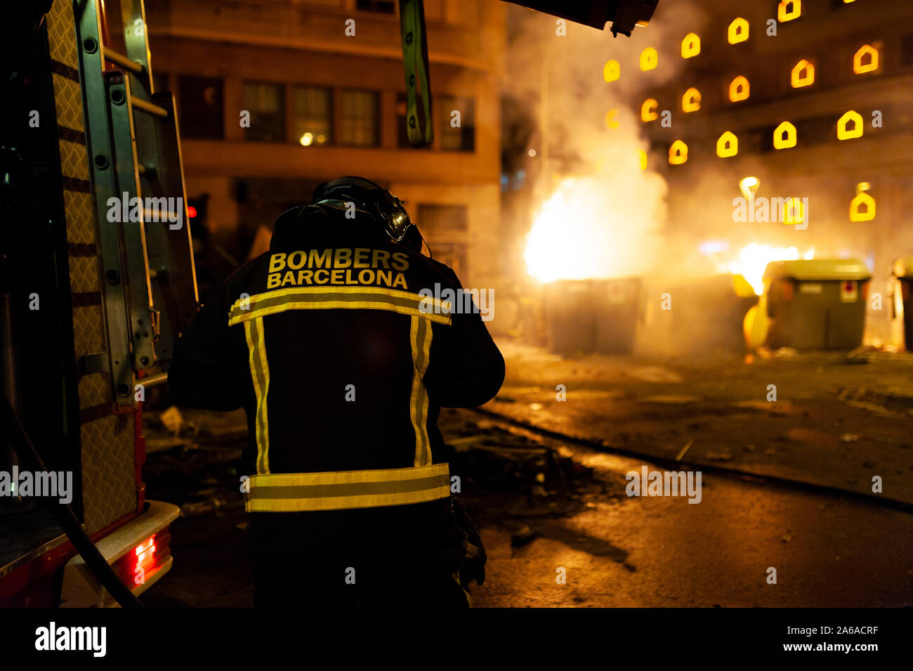 Barcellona, Spagna - 19 ottobre 2019: un vigile del fuoco di notte con il fuoco in background, lavorando in una pericolosa situtation durante il catalano sommosse con po Foto Stock