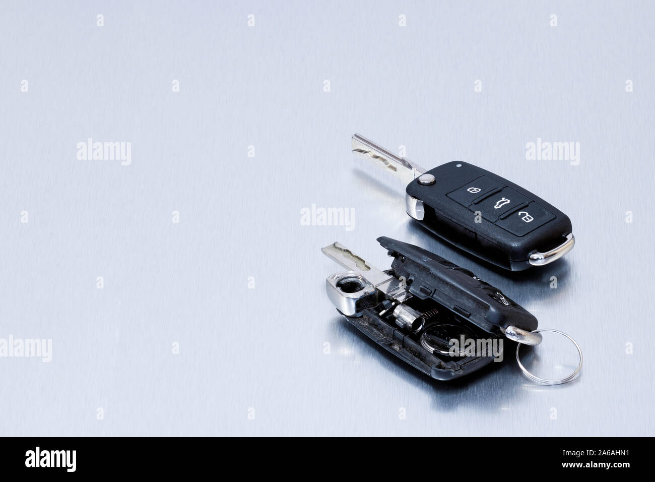 Rotto o danneggiato auto key fob e nuovo telecomando chiave del veicolo su  sfondo di alluminio.