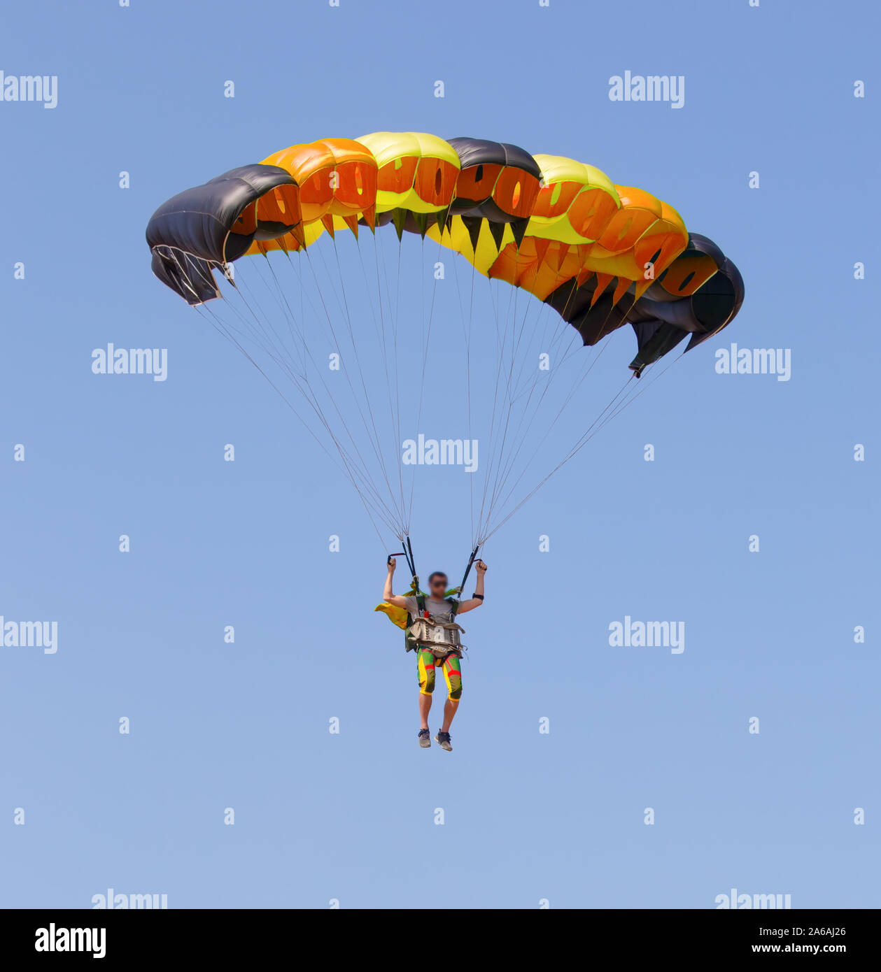 Paracadutista sotto la tettoia di un paracadute nel cielo blu. Il volto è sfocato e irriconoscibile in bicchieri Foto Stock
