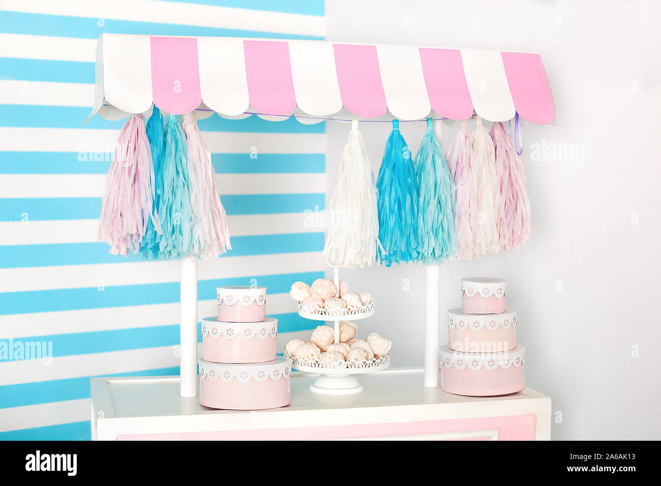 Camera per bambini con striscia blu sullo sfondo. candy stallo zona foto con grande amaretti, dolciumi e marshmallows. Carrello con gelato. Camera decorata Foto Stock