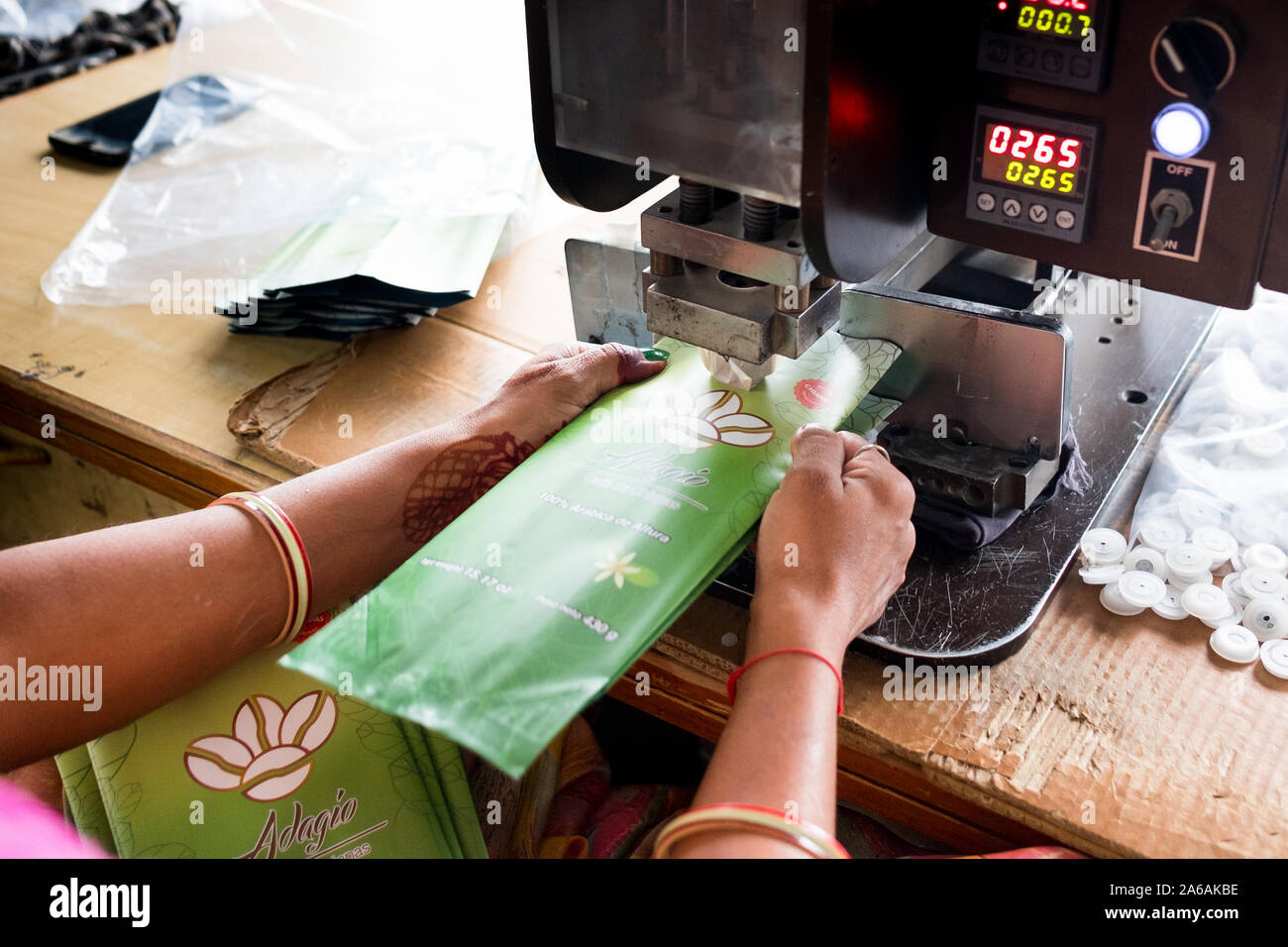 New Delhi, India - 10 settembre 2019: close up della donna indiana mani utilizzando apparecchiature industriali imballaggio interno impianto di fabbricazione Foto Stock