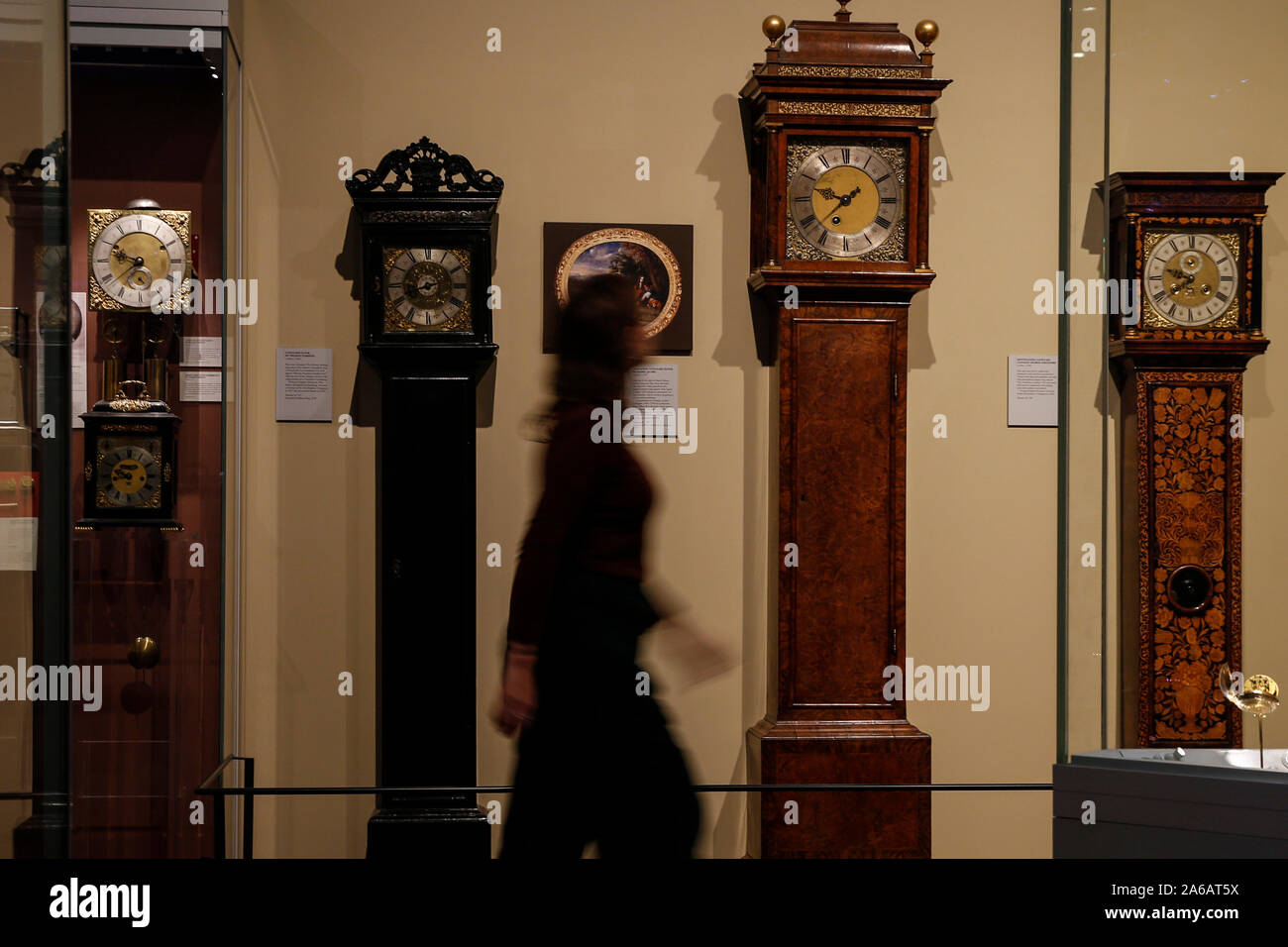 Una donna cammina passato nonno orologi sul display in corrispondenza della Clockmakers' museo, parte del Museo della Scienza di Londra, precedendo gli orologi di andare indietro di un'ora in questo fine settimana. Foto Stock