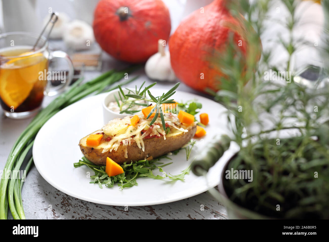 Patate al forno ripiene con formaggio, erba cipollina, burro, marinato e zucca freschi salsa di rosmarino Foto Stock