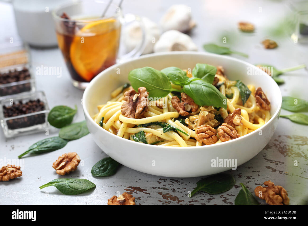 Spaghetti di arachidi in una salsa alla panna con spinaci freschi, aglio, pollo e noci Foto Stock