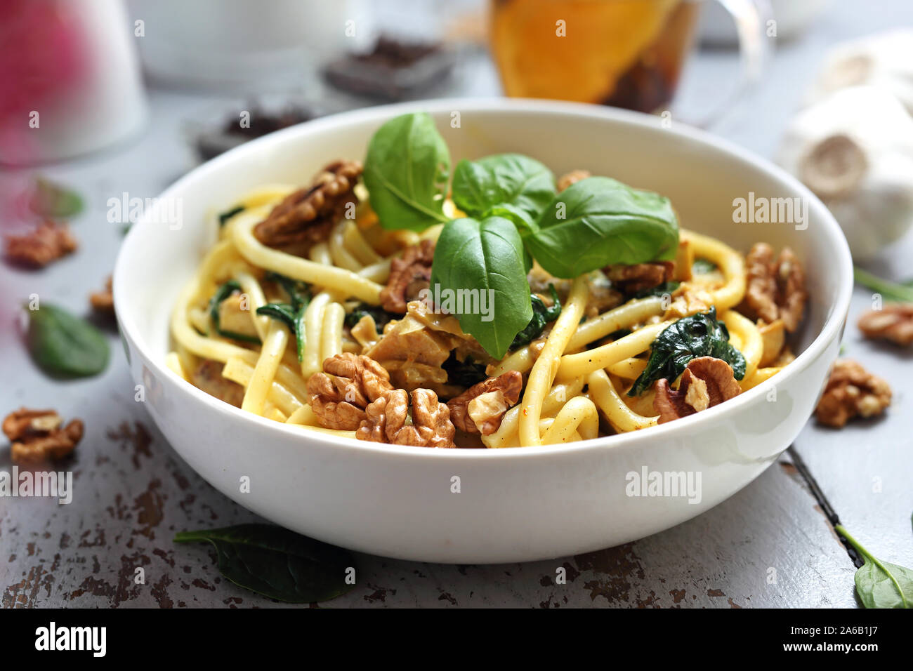 Spaghetti in salsa alla panna con spinaci freschi, aglio, noci Foto Stock
