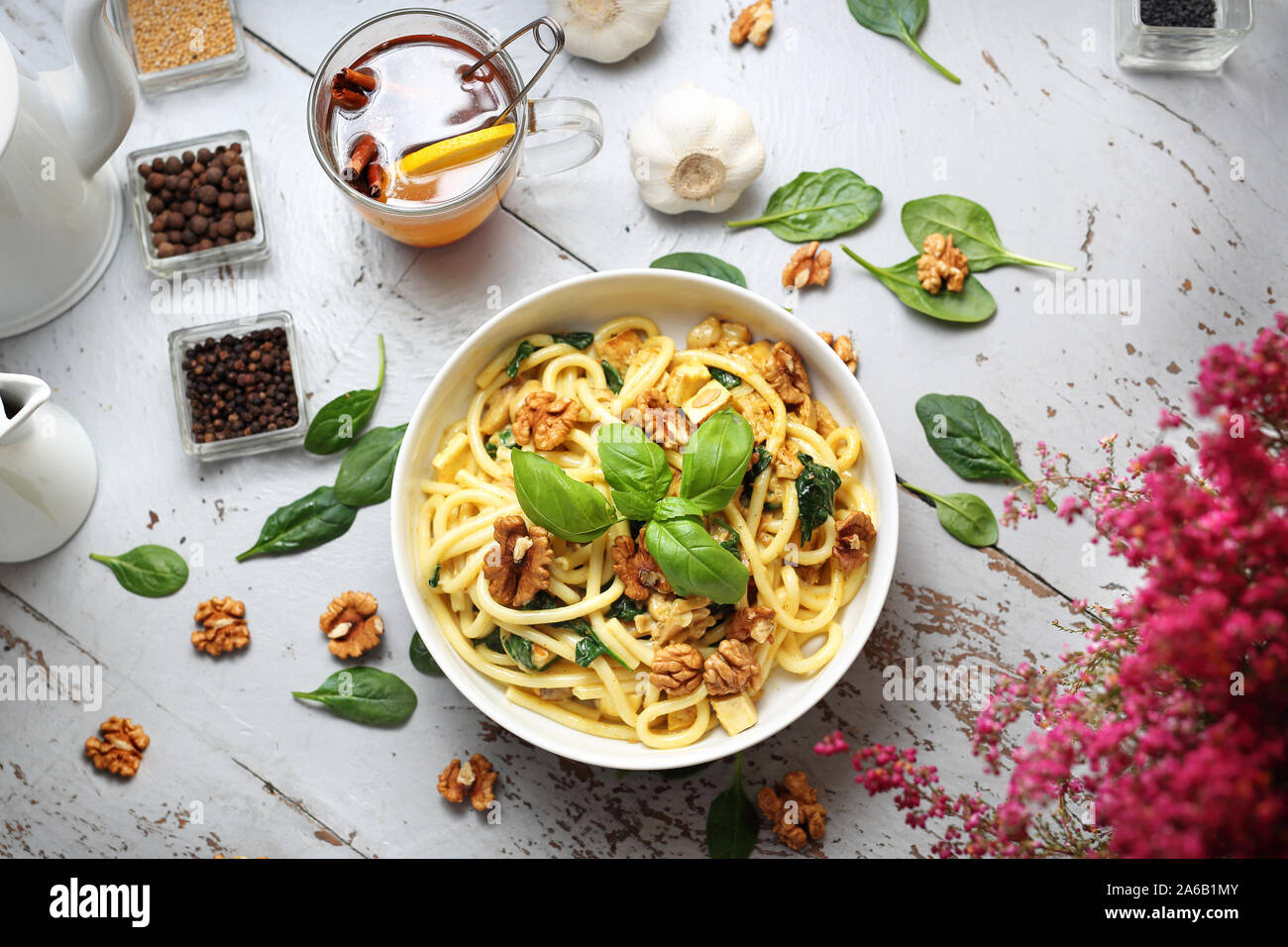 Spaghetti di pasta in una salsa alla panna con spinaci freschi, aglio, noci Foto Stock