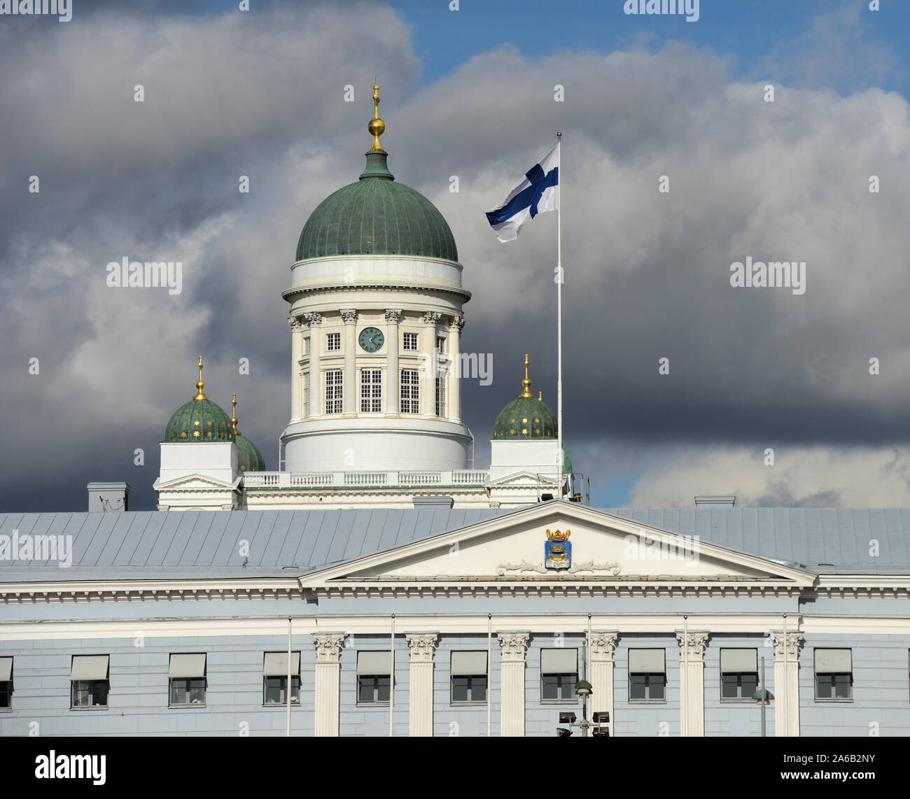 Svolazzanti bandiera nazionale della Finlandia contro la Cattedrale di Helsinki, più prominente edificio e simbolo della città Foto Stock
