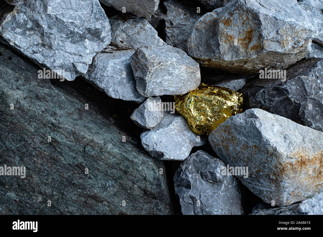 Pepita d'oro e il granito grigio sfondo di pietra Foto Stock