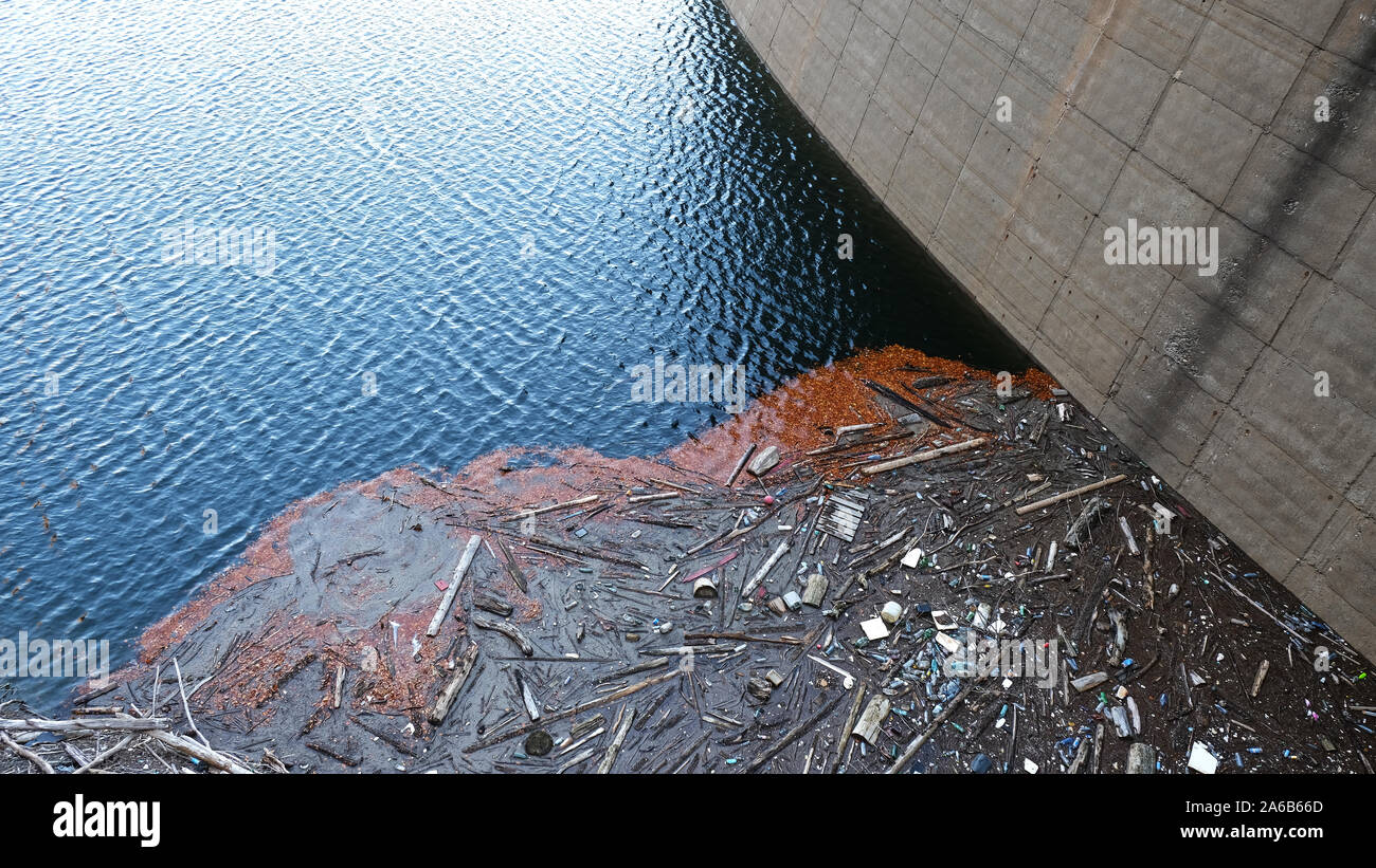 Diga di Vidraru, Romania - 12 Ottobre 2019: residui di plastica sul bordo del lago Vidraru nella contea di Arges, Romania, in contrasto con le chiare acque blu o Foto Stock