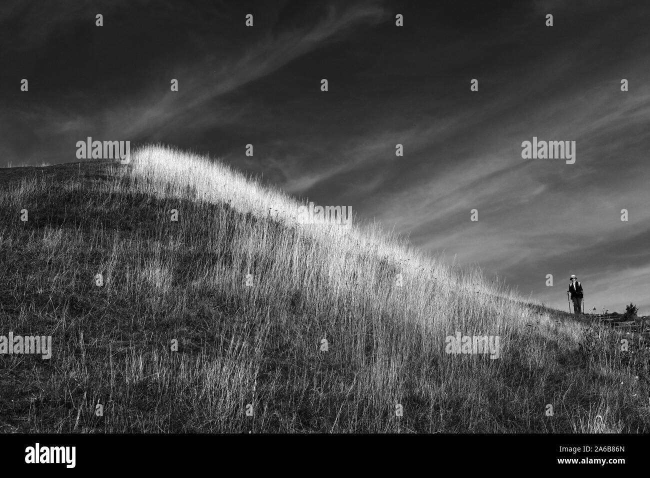 Una donna che cammina verso il basso di una collina. Foto Stock