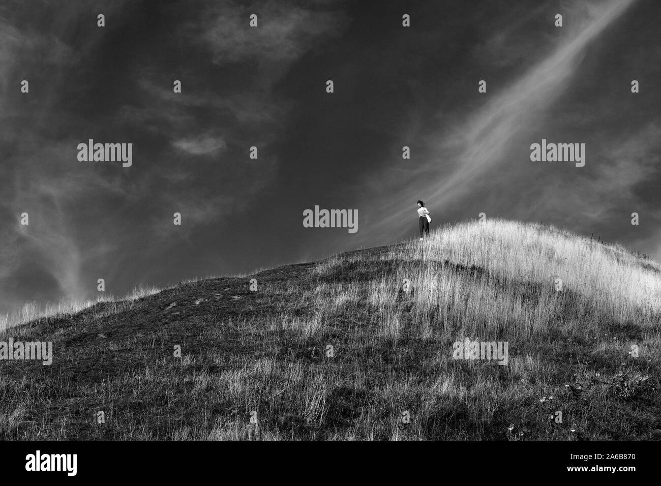 Una giovane donna che cammina verso il basso di una collina. Foto Stock