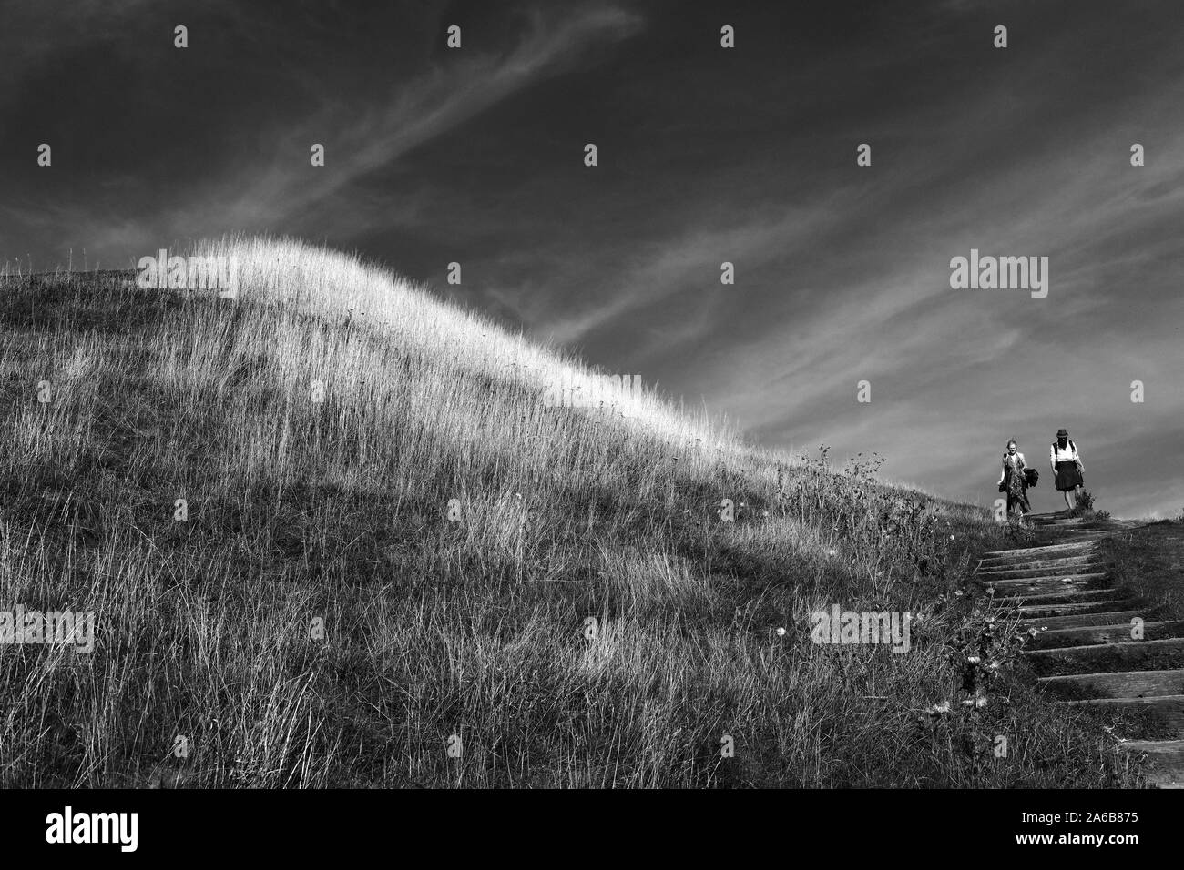 Due persone che camminano giù per una collina. Foto Stock
