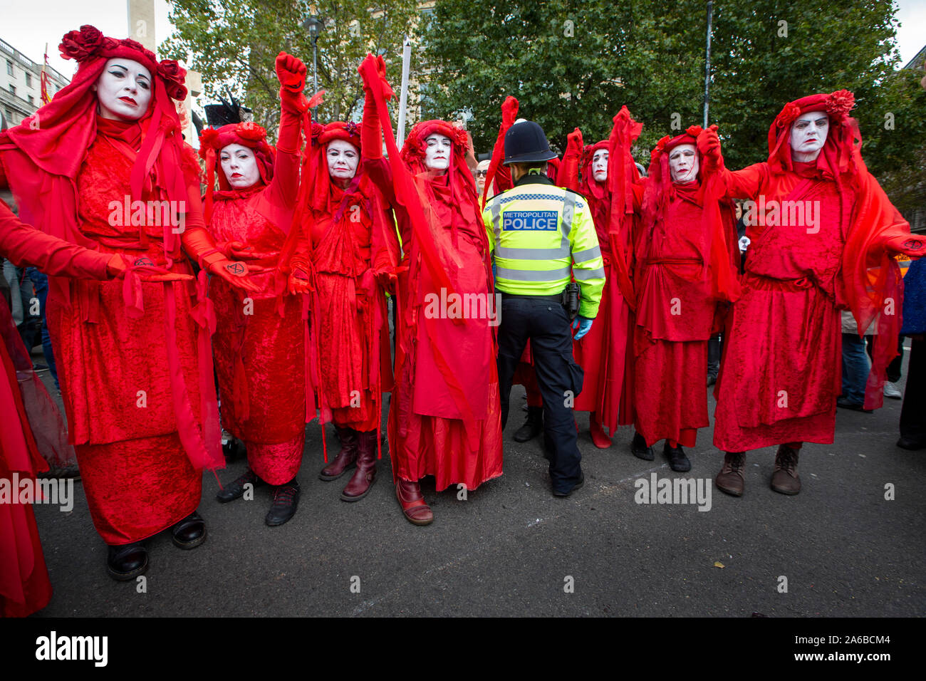 Londra, 10 ottobre 2019, estinzione della ribellione gruppo in costume rosso polizia circondano la preparazione di arresto acivists che hanno bloccato se stessi a una struttura in legno nella strada accanto a Trafalgar Square. Foto Stock