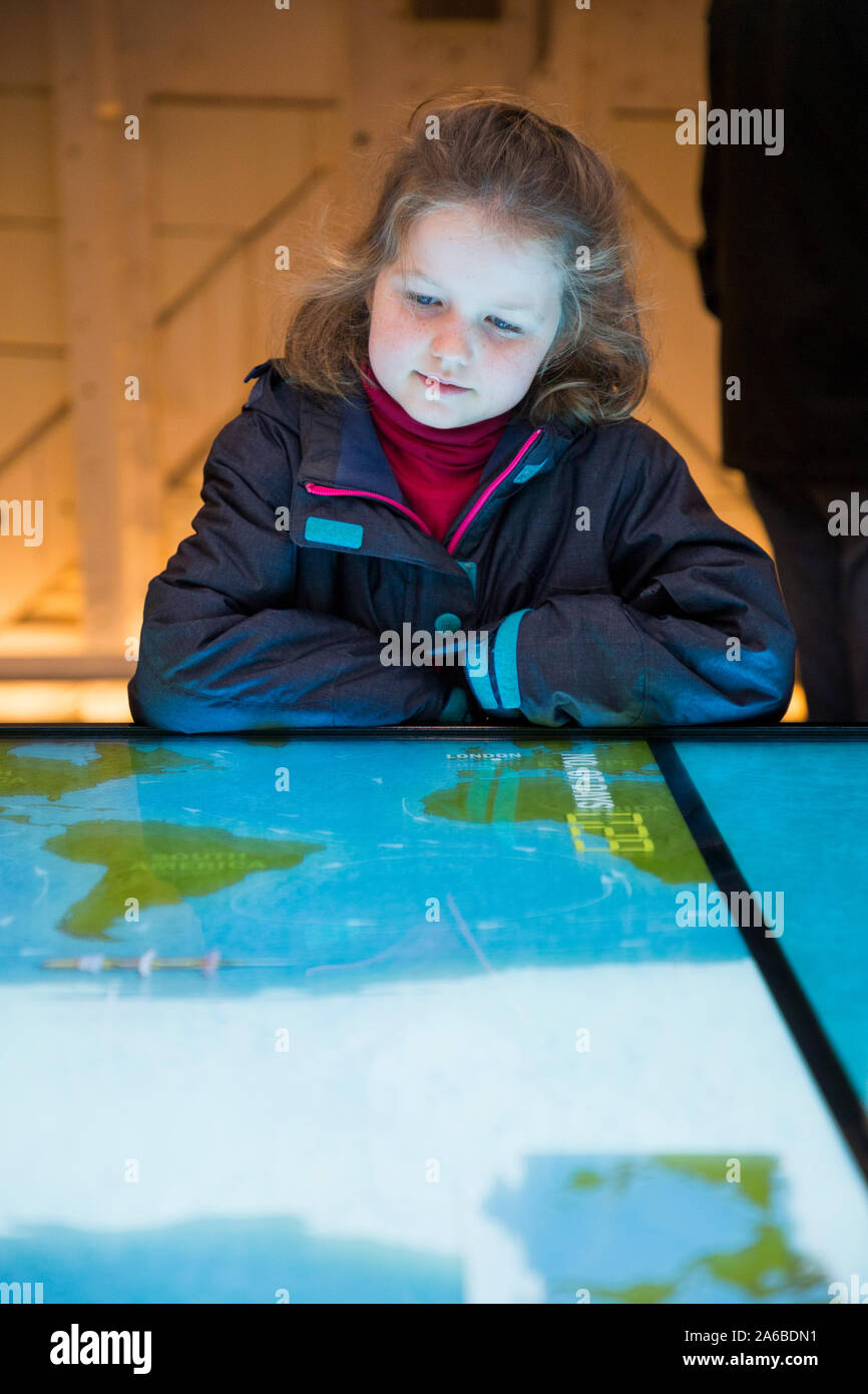 Famiglia e bambini al di sopra dei pori capitano Woodget interattiva del gioco dello sterzo, una Mappa grafico del globo mondo per navigare il percorso migliore e sterzo e guida il modo / trova il più veloce il passaggio dal mare in Australia dal Regno Unito per la nave a vela il Cutty Sark. Greenwich, Londra UK (105) Foto Stock