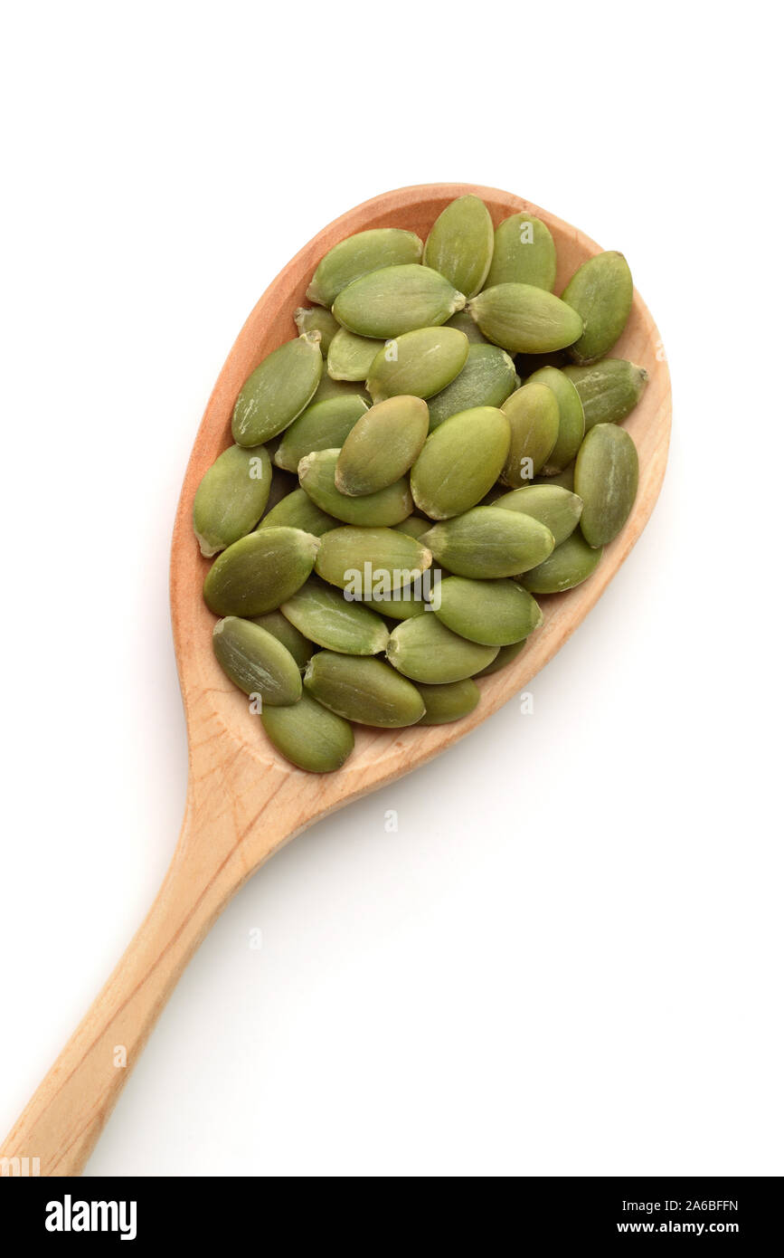 Vista dall'alto di semi di zucca in cucchiaio di legno isolato su bianco Foto Stock
