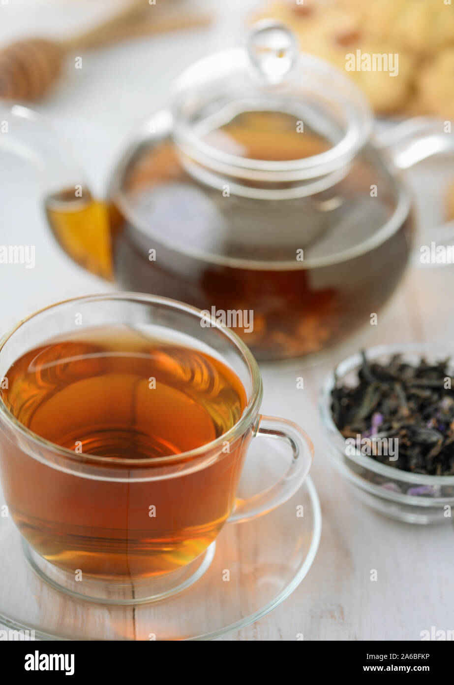 Teiera in vetro e la tazza di tè alle erbe su bianco tavolo in legno Foto Stock