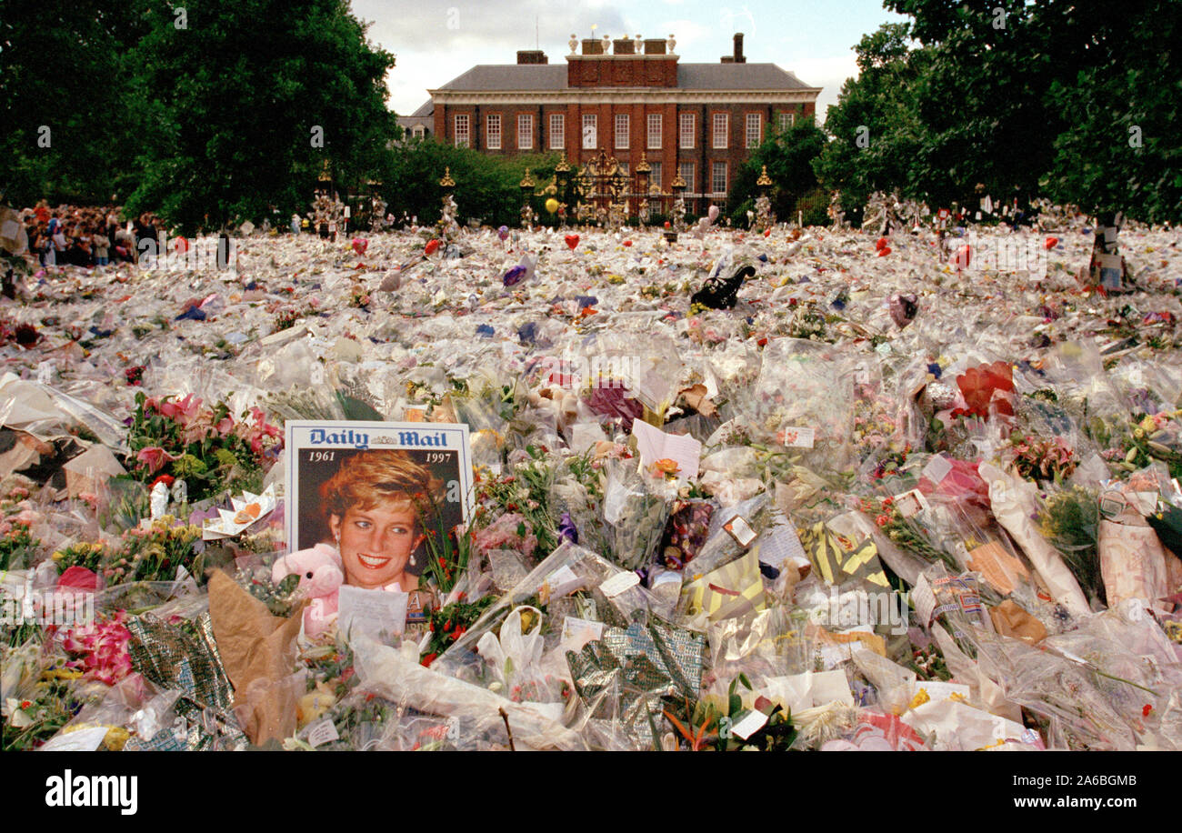 Fiori e persone in lutto al di fuori Kensington Palace nei giorni seguenti il funerale della principessa Diana, a Londra, Inghilterra, settembre 1997. Foto Stock