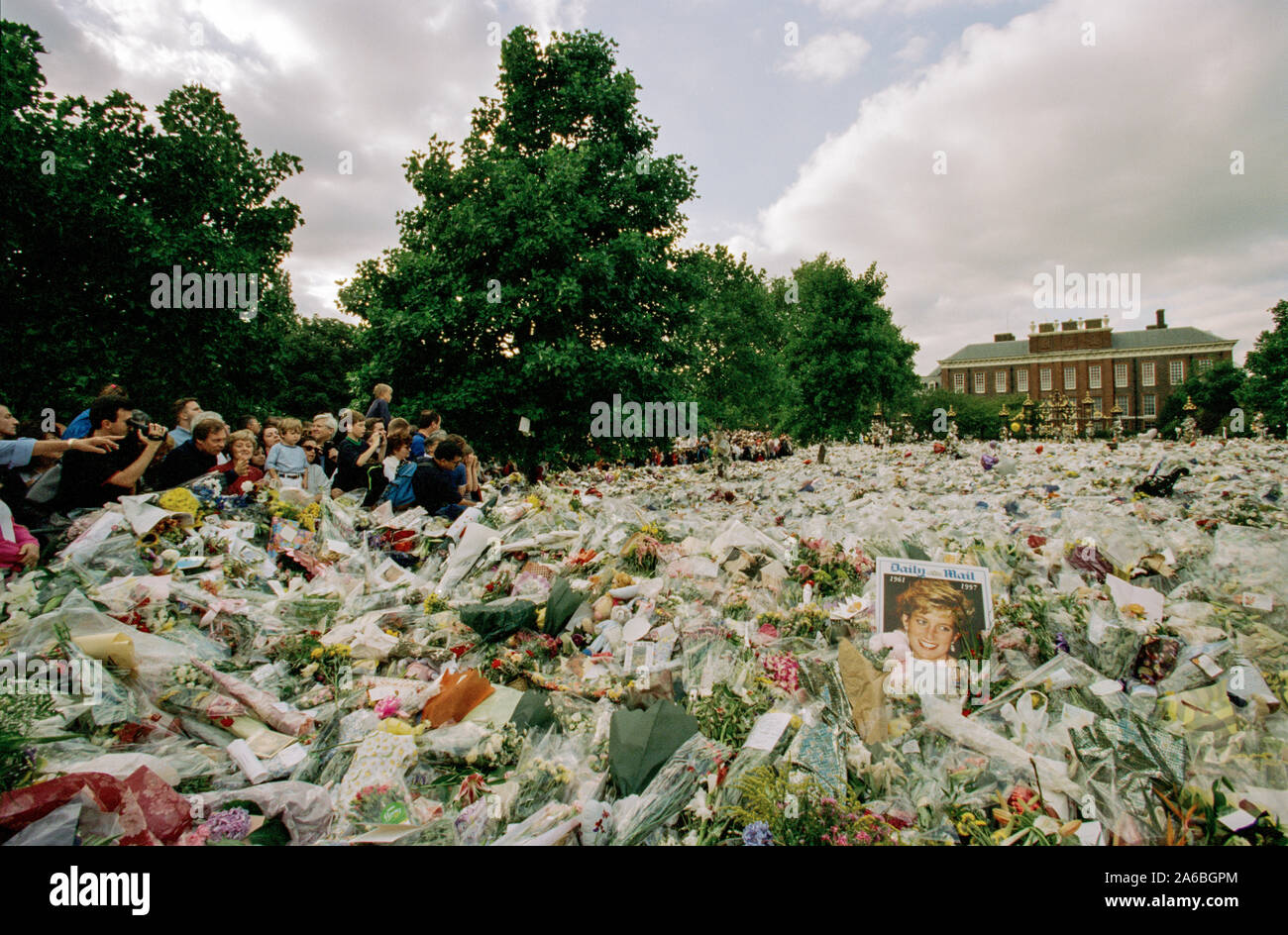 Fiori e persone in lutto al di fuori Kensington Palace nei giorni seguenti il funerale della principessa Diana, a Londra, Inghilterra, settembre 1997. Foto Stock