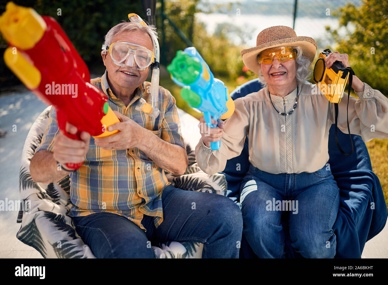 Vecchio felici le persone a divertirsi giocando con la pistola ad acqua. Foto Stock