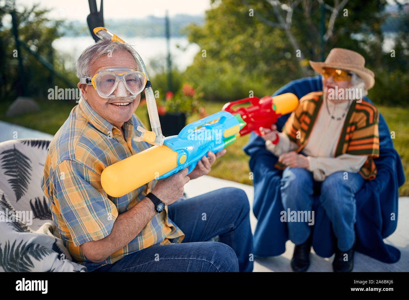 Crazy coppia Senior.felice coppia senior in vacanza giocando con la pistola ad acqua. Foto Stock