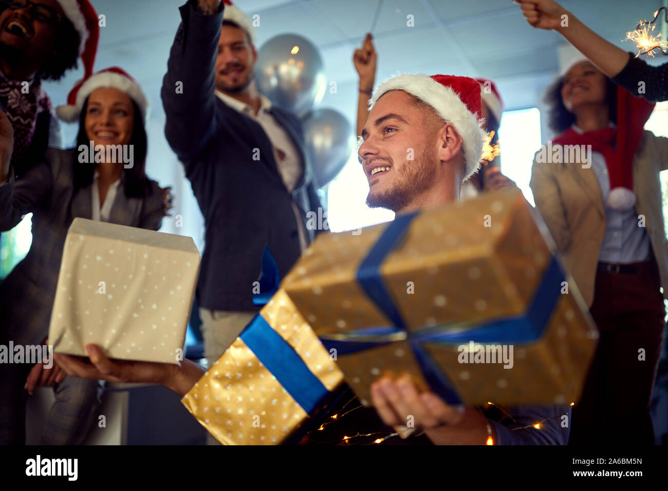 Gruppo di felice impiegati celebrando il Natale.giovane uomo sorridente in santa hat a Xmas Party. Foto Stock