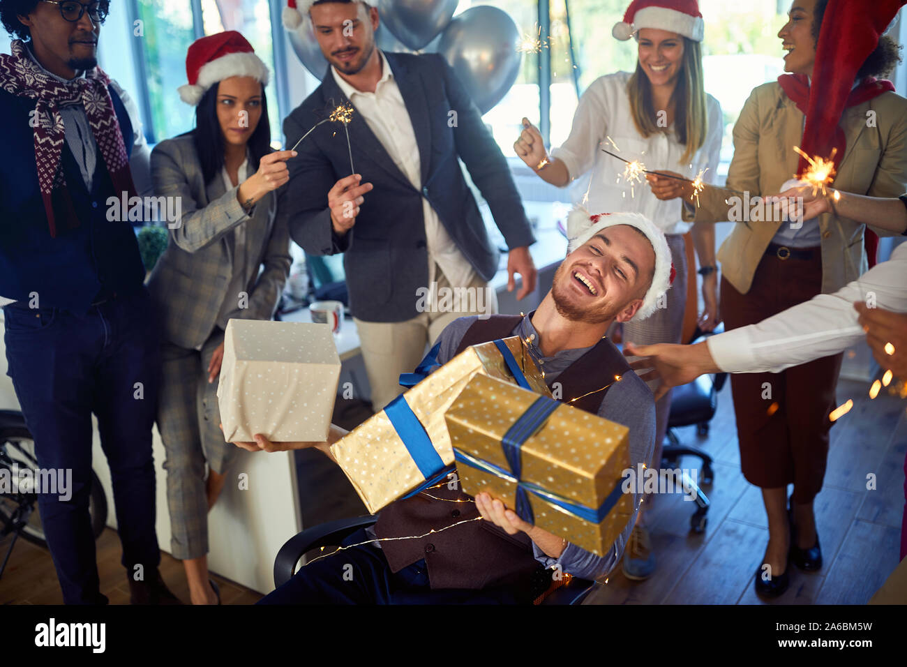 Gruppo di felice impiegati celebrando il Natale.giovane uomo sorridente e la donna a santa hat a Xmas Party. Foto Stock