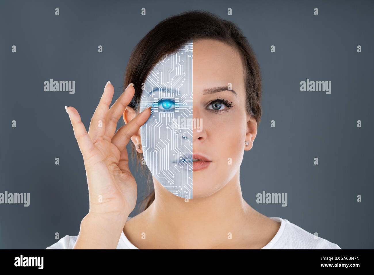 Close-up di due facce che mostra la donna e il Robot contro uno sfondo grigio Foto Stock