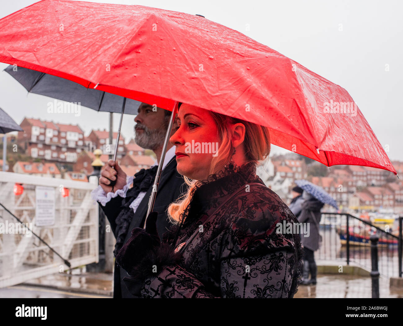 Goth matura in costumi tradizionali in piedi nella pioggia, Whitby Goth Festival Weekend, Whitby, North Yorkshire, Regno Unito, 25 Ottobre 2019 Foto Stock