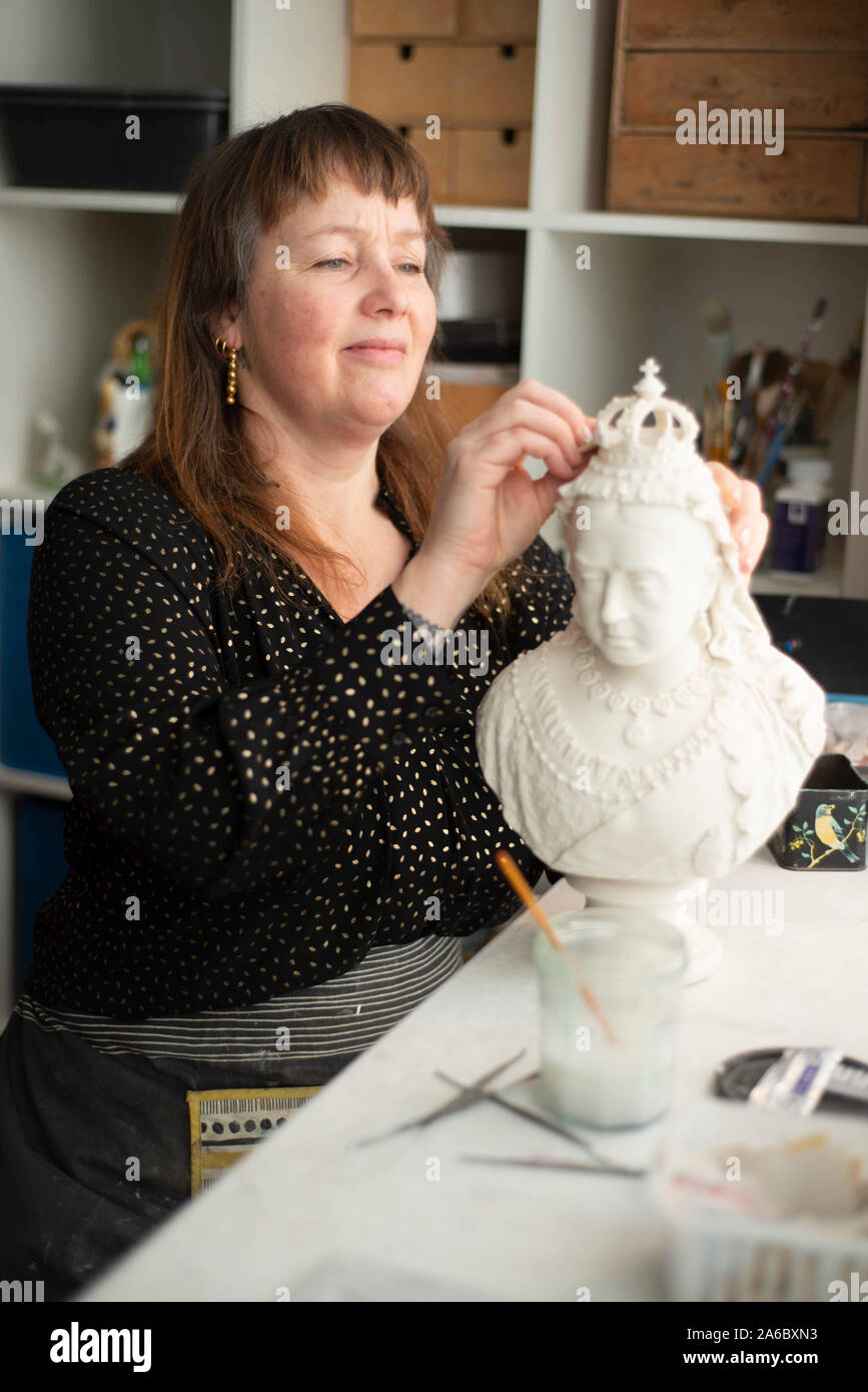 Un artista femminile lavora al restauro di una regina Victoria busto Foto Stock