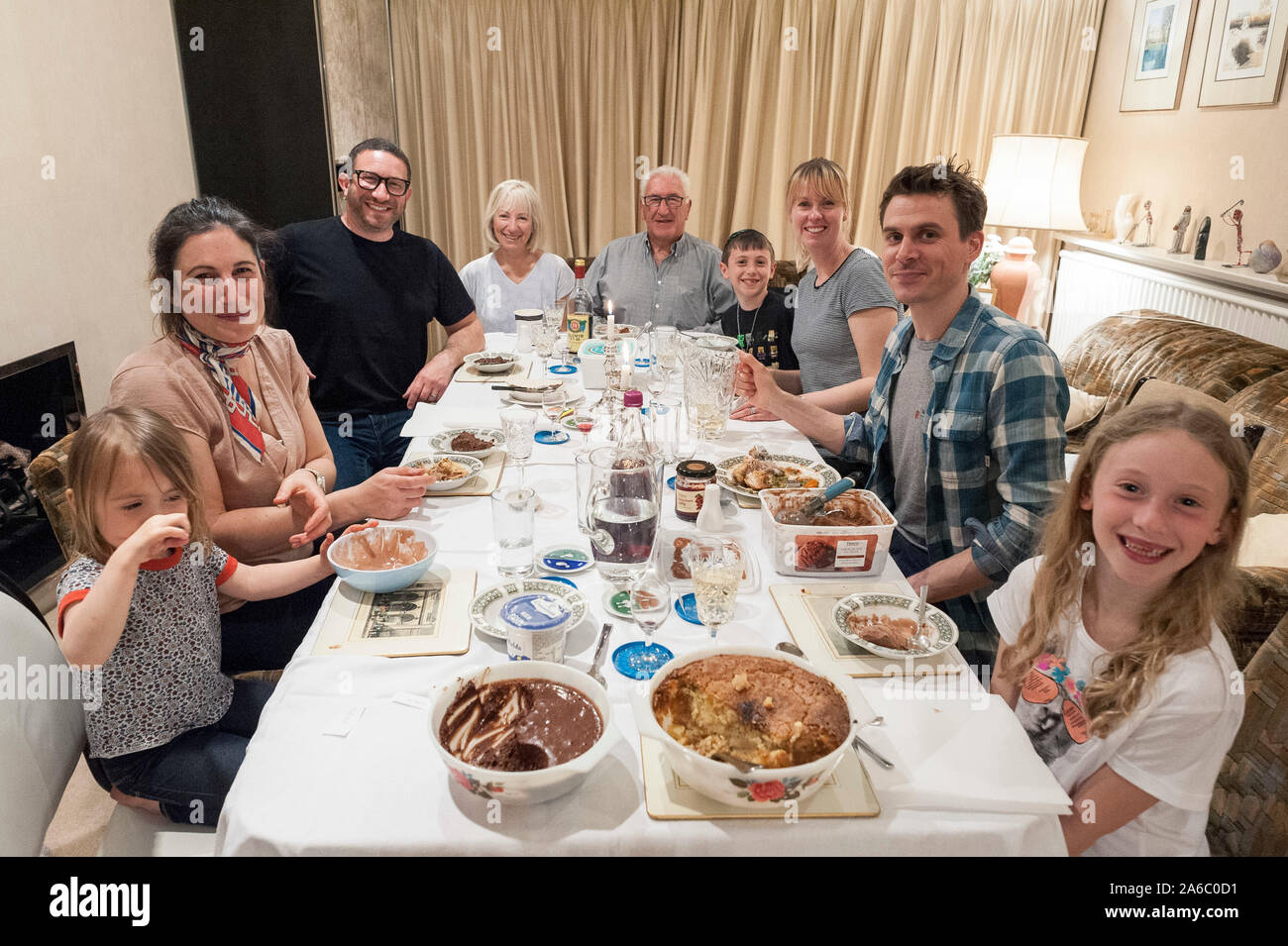 Una vera famiglia ebraica si siede attorno ad un tavolo da pranzo che celebra la festa ebraica della pasqua Foto Stock