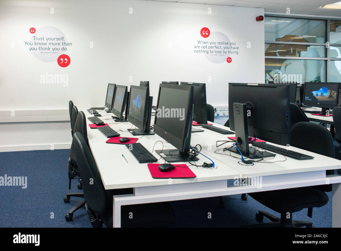 Un college o università biblioteca con libri sugli scaffali, gli studenti e i computer Foto Stock