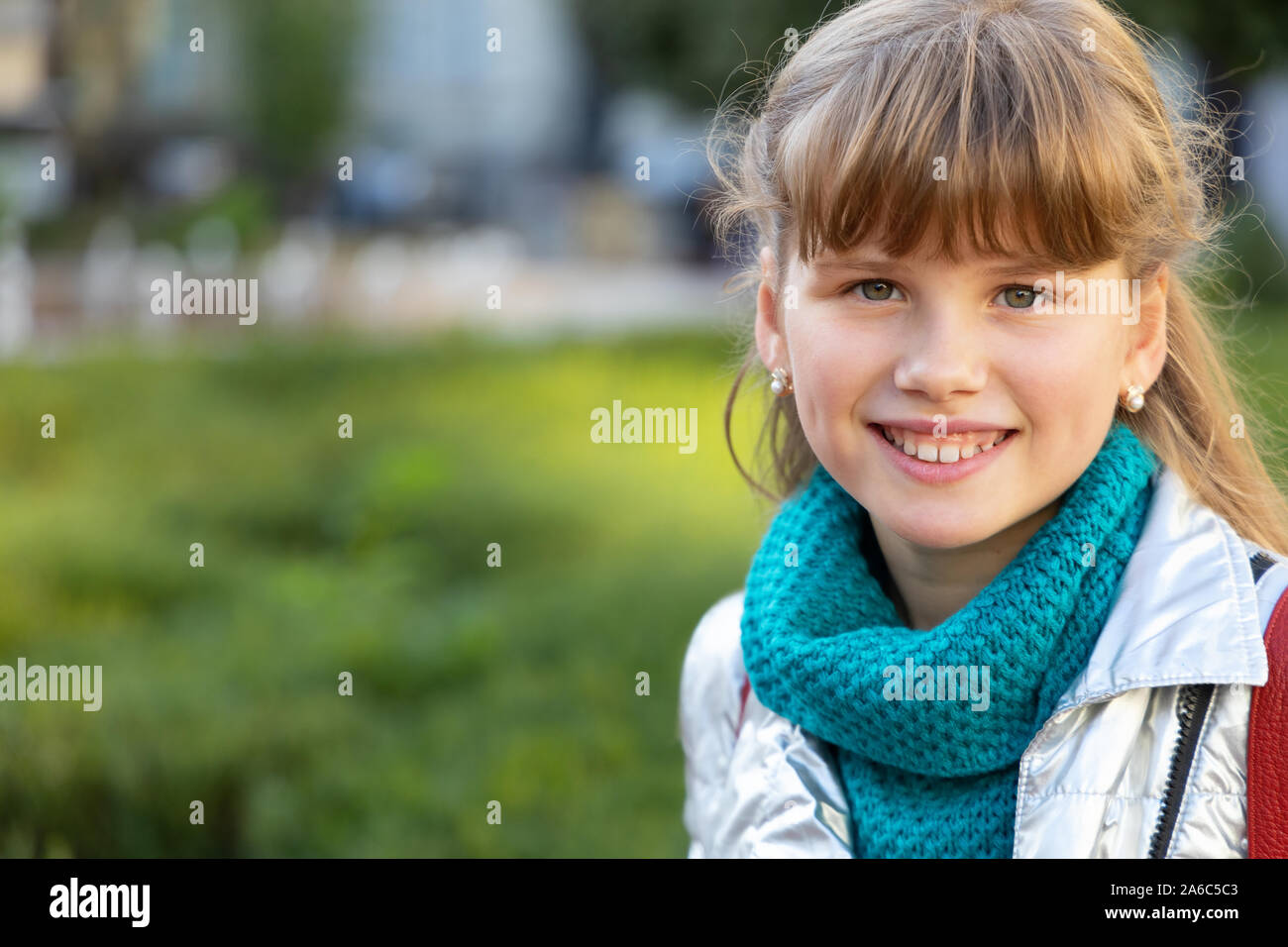 Close-up verticale ragazza 9-10 anni contro lo sfondo della città. Foto Stock