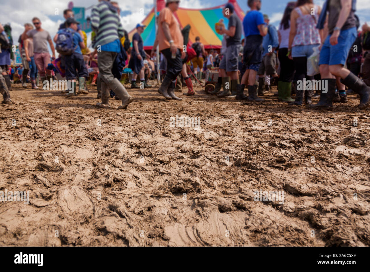 La gente trascinarsi faticosamente in condizioni fangose a un festival di musica. Foto Stock