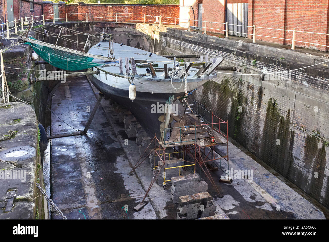 Yacht in legno in un Gloucester bacino asciutto essendo riparato Foto Stock