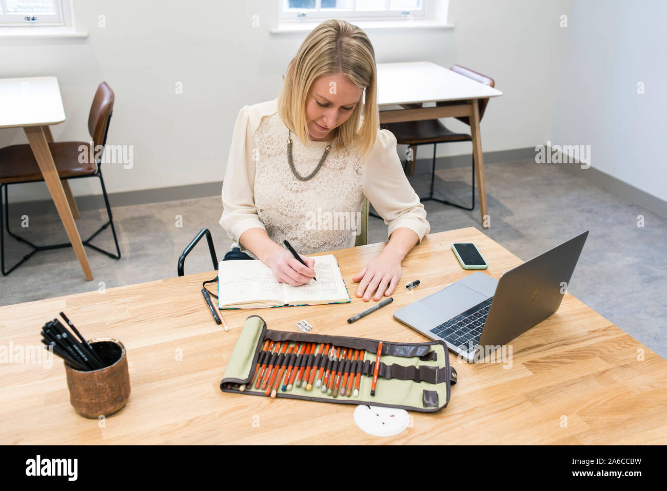 Lavorare in un ambiente di lavoro fresco e condividere lo spazio con altri lavoratori. Hot desking. Foto Stock