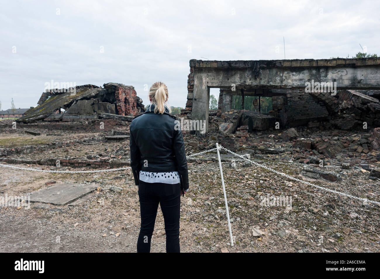 Una donna si distingue per le camere a gas del campo di concentramento di Auschwitz in Polonia Foto Stock