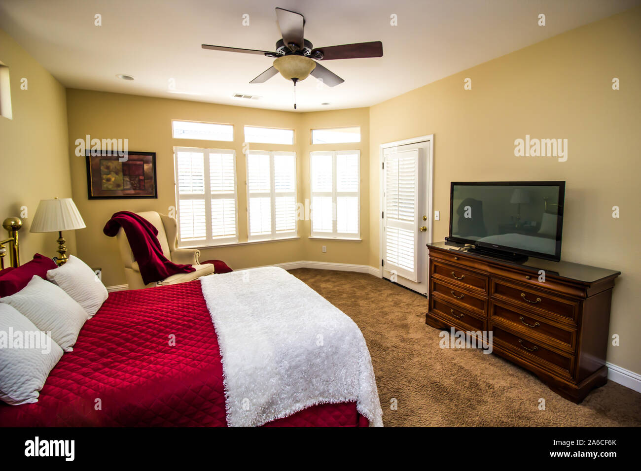 Camera da letto con cassettiera, televisione, letto Queen e Ann sedia Foto Stock