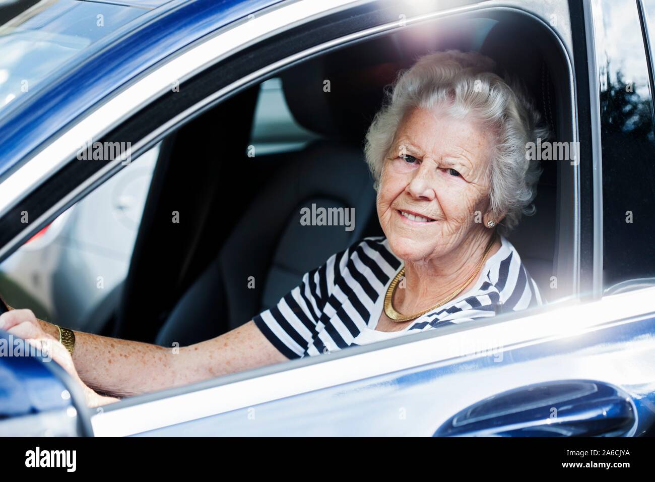 Senior donna alla guida di un'auto. Foto Stock