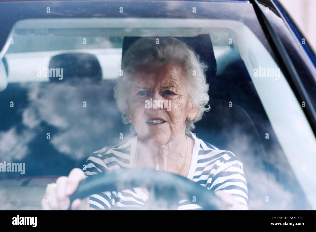 Senior donna alla guida di un'auto. Foto Stock