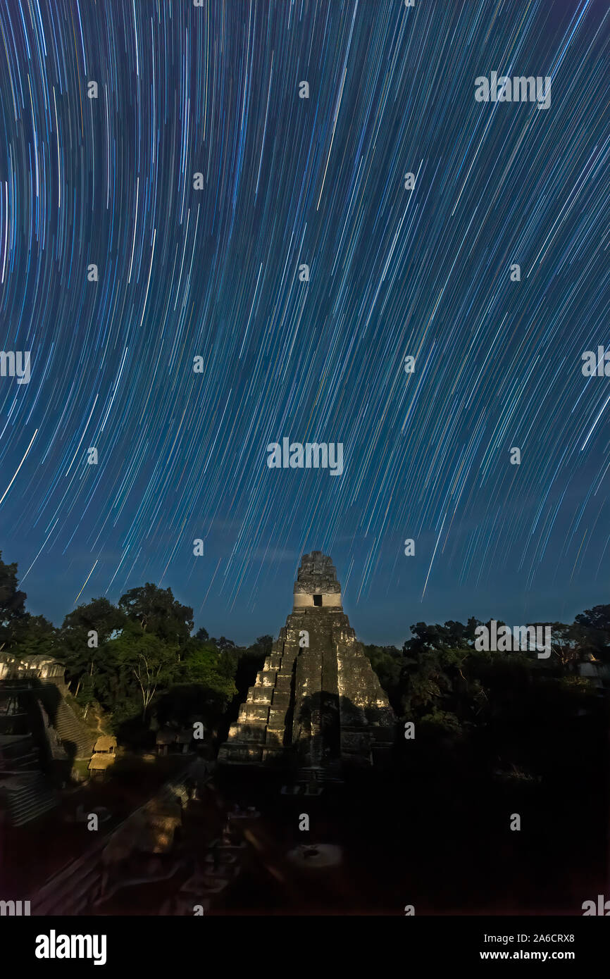 Tempio che io, Tempio della Jaguar, dalla luce della luna piena di notte con tracce stellari, Parco Nazionale di Tikal, Guatemala. Foto Stock