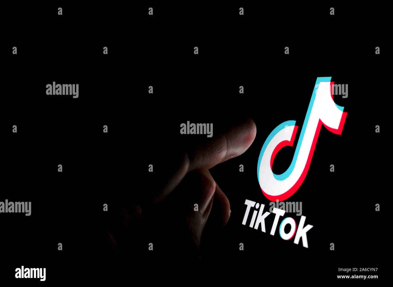 TikTok app logo sullo schermo e un dito circa di toccarla. Foto Stock