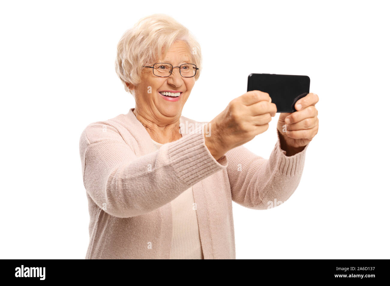 Donna anziana di scattare una foto con un telefono cellulare isolato su sfondo bianco Foto Stock