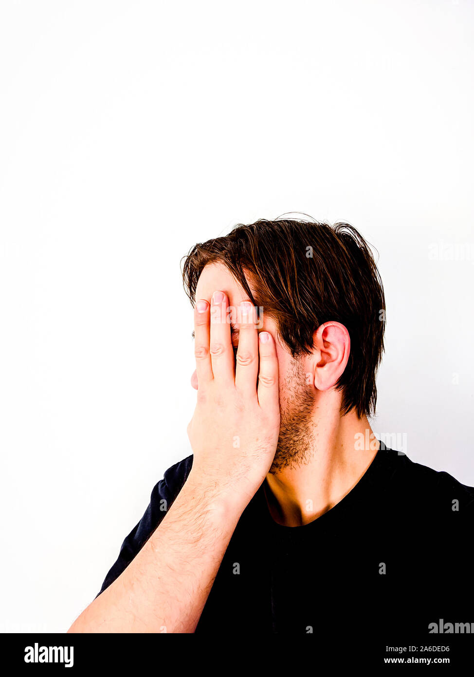 Uomo che ricopre la faccia con la mano in vergogna - Vista laterale Foto Stock