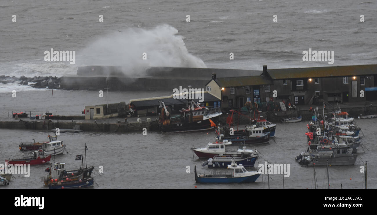 Lyme Regis, Dorset, Regno Unito. Il 26 ottobre 2019. Regno Unito: Meteo onde infrangersi oltre il Cobb e porto sulla parete una mattinata di forti venti e piogge. Credito: Celia McMahon/Alamy Live News. Foto Stock